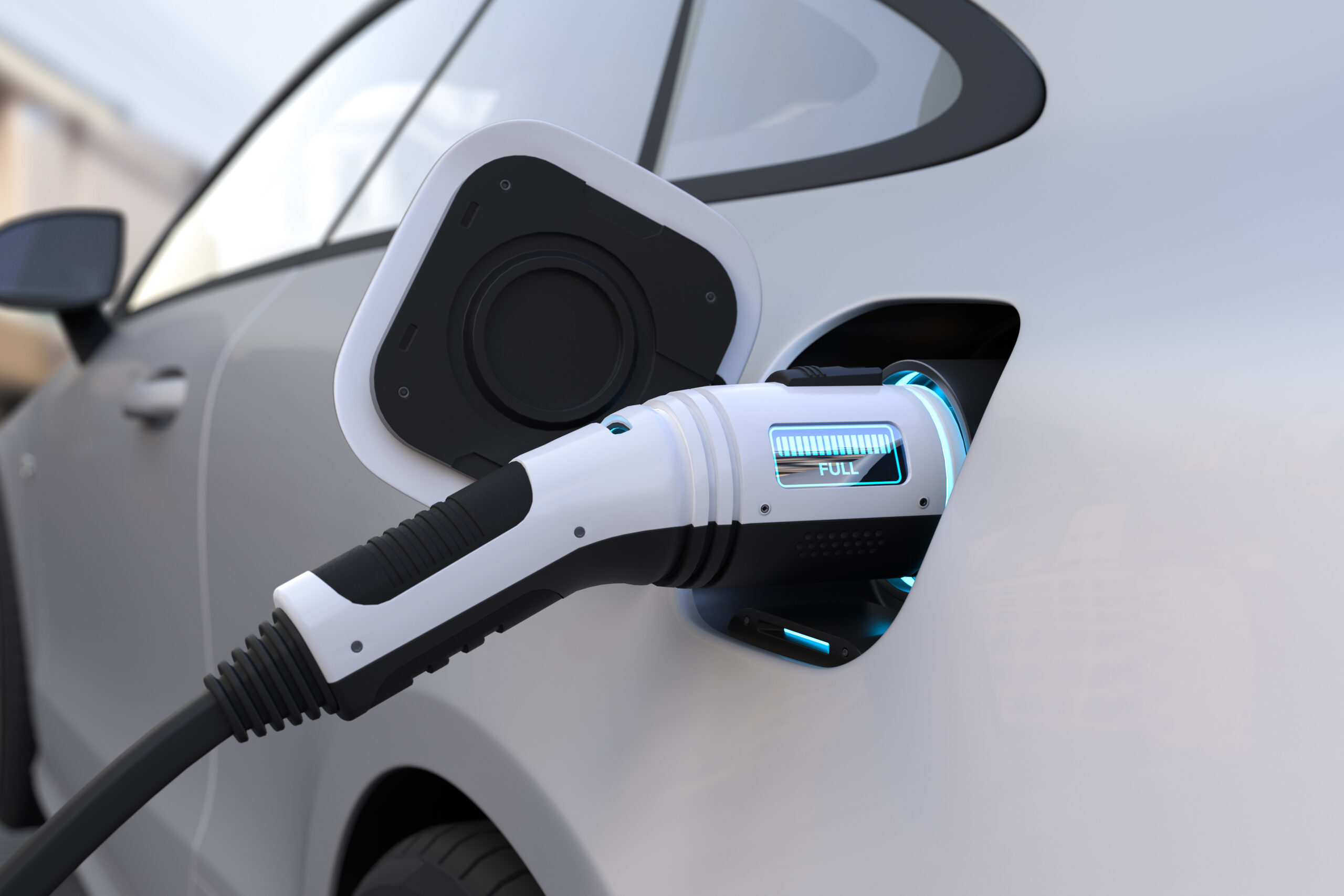 An electric vehicle is connected to a charging station, with a charging cable plugged into the vehicle's charging port. The port features illuminated indicators showing the charging status. The vehicle's exterior is sleek and modern, with a silver finish