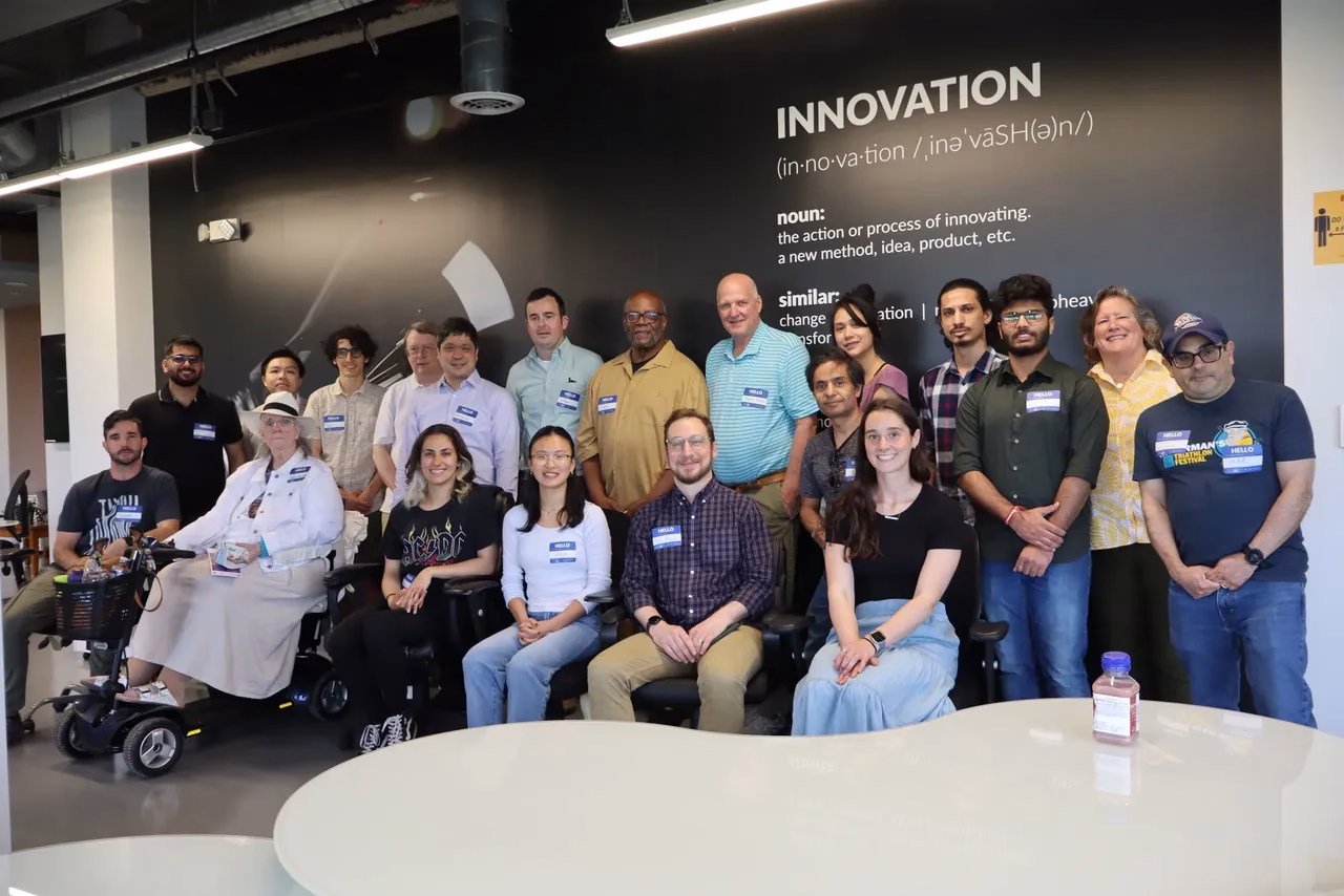 A diverse group of 20 individuals poses together in a modern workspace celebrating climate tech innovation.